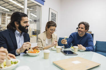 Happy colleagues having meal together in industry - JCCMF09967