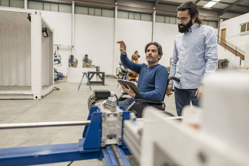 Ingenieur mit Kollege bei einer Diskussion in der Fabrik - JCCMF09977