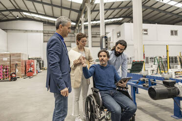 Disabled engineer having discussion with colleagues in industry - JCCMF09982
