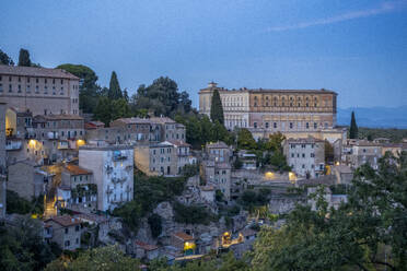 Italien, Latium, Caprarola, Altstadthäuser in der Abenddämmerung mit Villa Farnese im Hintergrund - MAMF02719