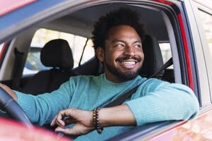 Happy man sitting in car - PNAF05139