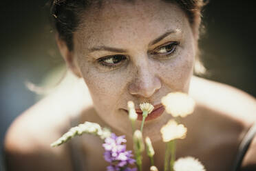 Thoughtful mature woman by flowers - MJRF00951