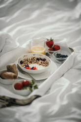 Tray of fresh breakfast on bed - MJRF00961