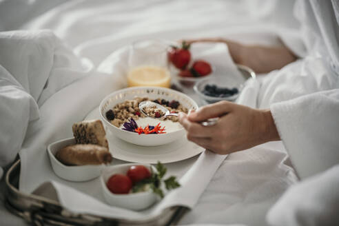 Frau mit Müsli beim Frühstück zu Hause - MJRF00962