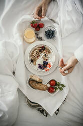 Woman having breakfast in bed at home - MJRF00964