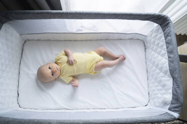 Cute baby boy lying in crib - NJAF00297