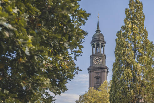 Deutschland, Hamburg, Glockenturm der St. Michaelskirche mit Bäumen im Vordergrund - KEBF02683