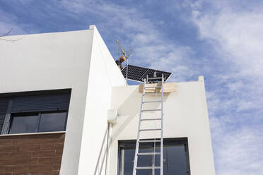Ingenieur mit Sonnenkollektor auf dem Dach - JCCMF10056