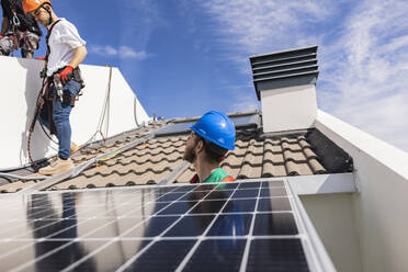Ingenieure installieren Solarzellen auf dem Dach - JCCMF10065