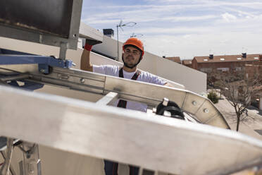 Young engineer working on rooftop - JCCMF10074