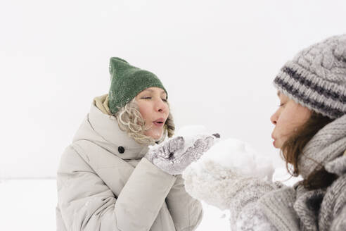 Glückliche Freunde, die sich gegenseitig mit Schnee bewerfen - SEAF01864