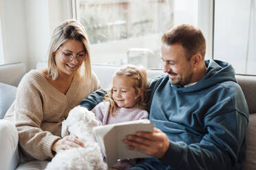 Happy family petting dog at home - MOEF04500