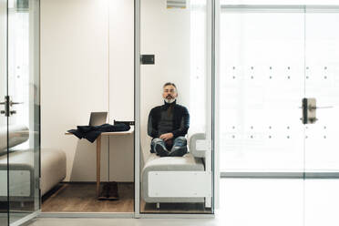 Businessman with eyes closed relaxing and taking break in office - JOSEF17946