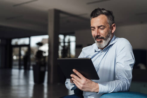 Lächelnder Geschäftsmann bei der Arbeit am Tablet-PC - JOSEF18005