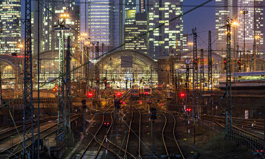 Germany, Hesse, Frankfurt, Tracks in front of train station at night - AMF09875