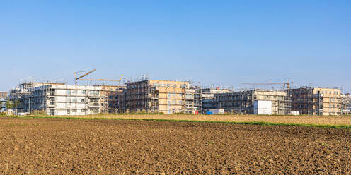 Deutschland, Baden-Württemberg, Sindelfingen, Feld mit Neubaugebiet im Hintergrund - WDF07295