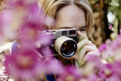 Frau fotografiert durch Kamera im Garten - JATF01351