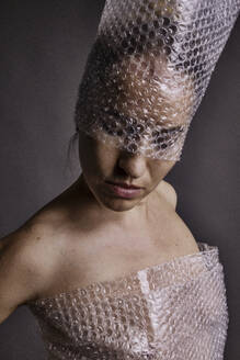 Woman wearing hat with bubble wrap - JATF01361