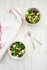 Two bowls of mixed vegetarian salad with pomegranate seeds and feta cheese - LVF09289