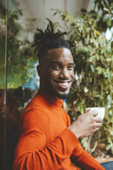 Happy young man holding coffee cup - JOSEF18100