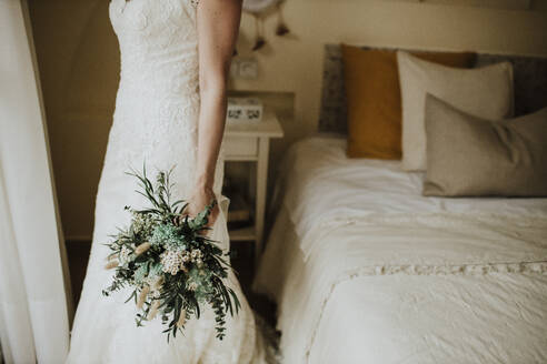 Braut hält Blumenstrauß im Schlafzimmer - GMLF01333