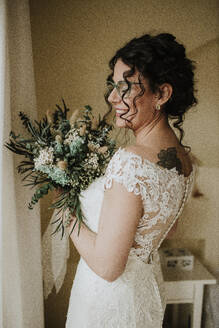 Glückliche Braut mit Blumenstrauß - GMLF01334