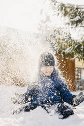 Boy wearing knit hat playing in snow - SEAF01874