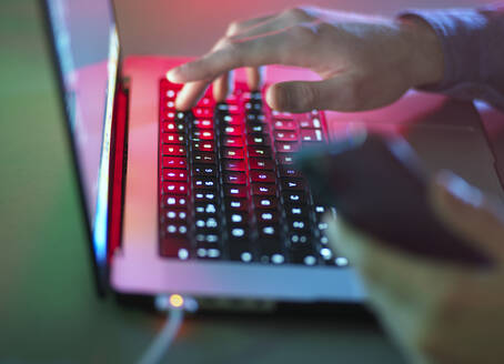 Hände tippen auf Laptop-Tastatur in der Dunkelheit im Büro - ABRF01068
