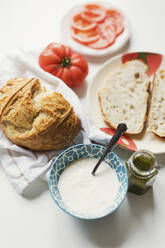 Handwerklich hergestelltes Brot mit Käse und Pestosauce auf dem Tisch - ONAF00453