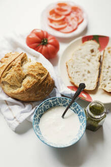 Handwerklich hergestelltes Brot mit Käse und Pestosauce auf dem Tisch - ONAF00453