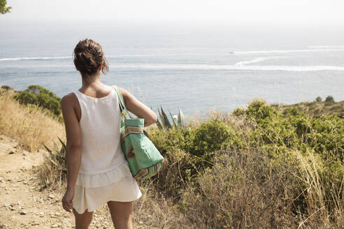 Frau mit Tasche geht am sonnigen Tag zum Meer - PCLF00303