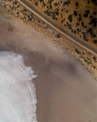 Luftaufnahme einer Eisenbahnlinie entlang des Strandes mit an die Küste rollenden Meereswellen. - AAEF17762