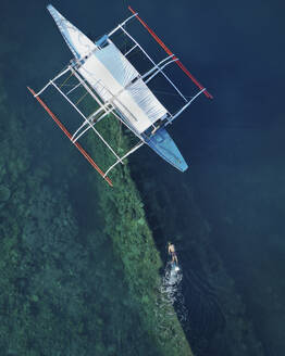 Aerial view of a person snorkelling near Lusong Gunboat Shipwreck on Coron Island, Bayan ng Coron, Palawan, Philippines. - AAEF17782