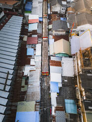 Luftaufnahme eines Zuges, der durch den Rom Hup Markt in Bangkok, Thailand fährt 3. - AAEF17850