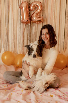 Glückliche Frau feiert den Geburtstag ihres Border Collie Hundes - GMLF01367