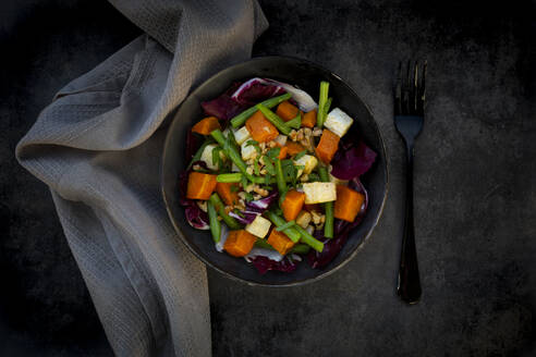 Bowl of ready-to-eat vegetarian salad with sweet potato, celery, radicchio, green beans, croutons, walnuts and parsley - LVF09299