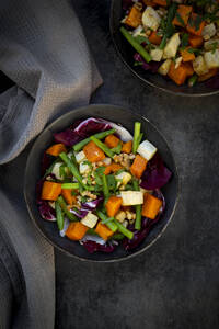 Zwei Schalen verzehrfertiger vegetarischer Salat mit Süßkartoffeln, Sellerie, Radicchio, grünen Bohnen, Croutons, Walnüssen und Petersilie - LVF09300