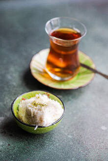 Turkish cotton candy sweets and black tea in the glass served on concrete background - ADSF43553