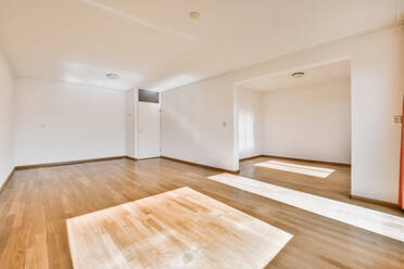 Innenraum eines geräumigen Zimmers mit weißen Wänden und Holzboden in einer modernen Wohnung - ADSF43724