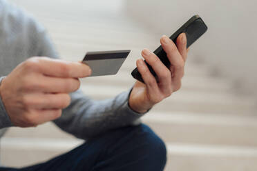 Hands of businessman holding credit card and smart phone - JOSEF18129