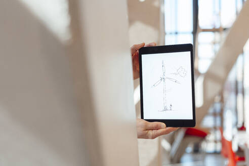 Geschäftsmann zeigt Zeichnung einer Windkraftanlage auf einem Tablet-PC im Büro - JOSEF18140