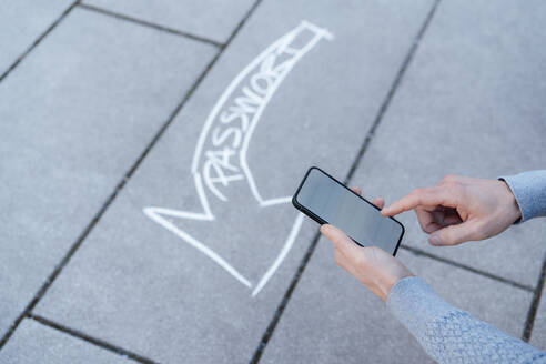 Mann benutzt Smartphone mit Textpfeil auf dem Fußweg - JOSEF18168