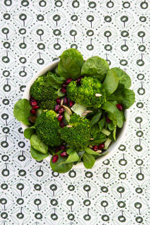 Bowl of green salad with broccoli, corn salad, cashews, cucumber and various seeds - LVF09303