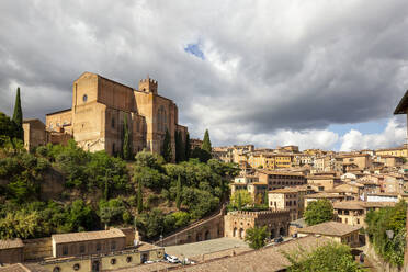 Italien, Toskana, Siena, Dicke Wolken über der Basilika von San Domenico und den umliegenden Häusern - MAMF02750