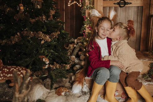 Bruder küsst Schwester zu Weihnachten auf die Wange - GMLF01389