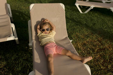 Girl relaxing on lounge chair in resort - VIVF00498