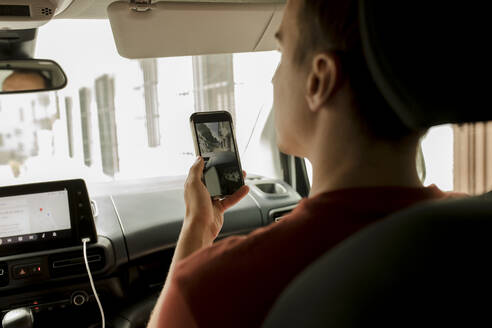 Mann mit Smartphone im Auto sitzend - VIVF00509