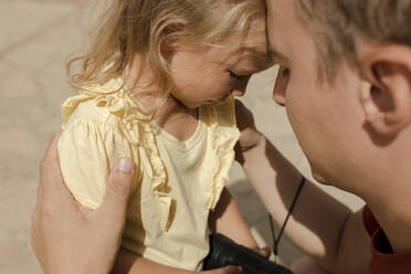 Vater tröstet niedliche traurige Tochter an einem sonnigen Tag - VIVF00514