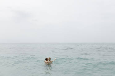 Couple swimming together in sea - VIVF00528