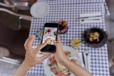 Frau fotografiert Essen mit ihrem Smartphone - VIVF00549